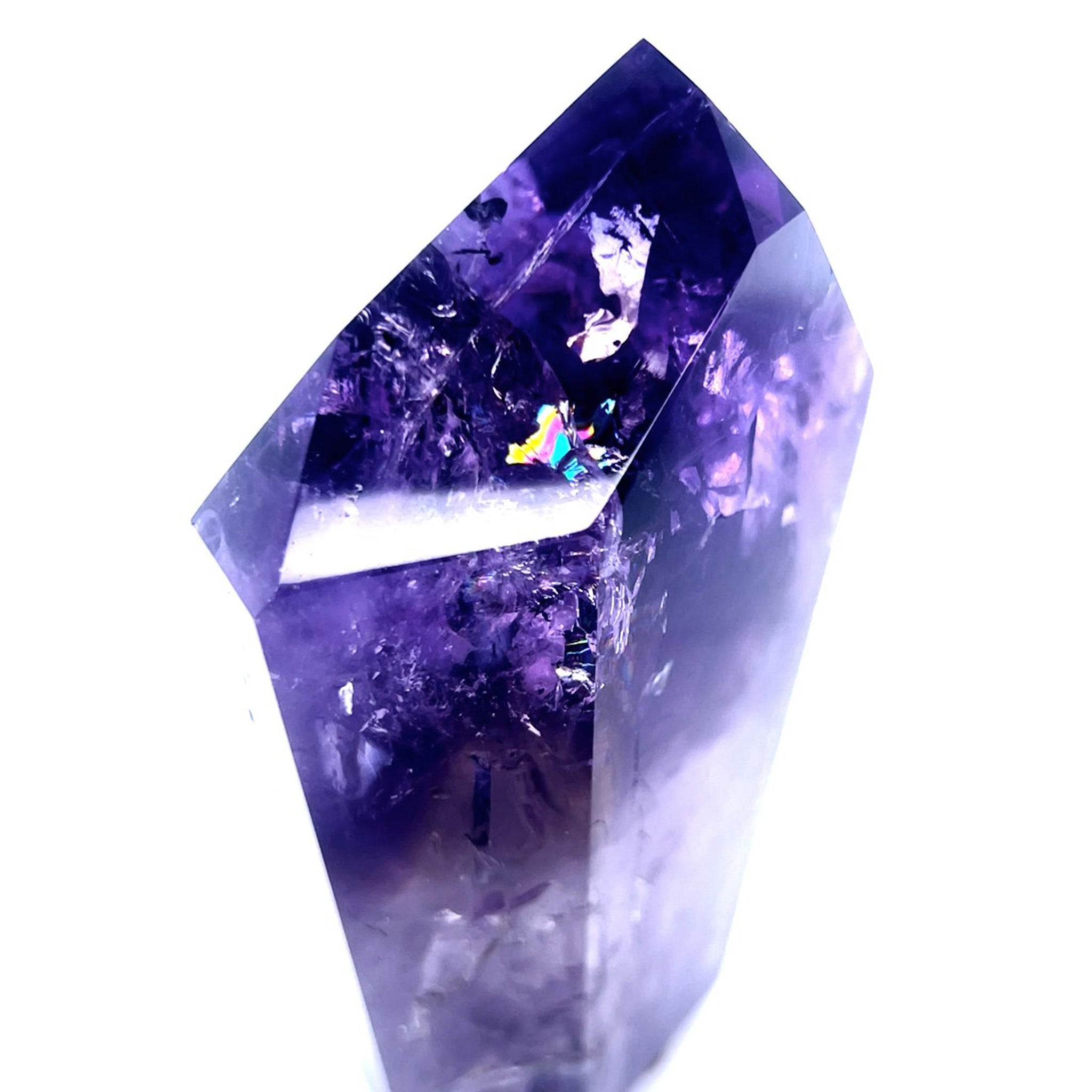 A natural purple amethyst crystal point with visible internal inclusions and sparkling rainbows, photographed against a solid white background.