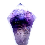 A natural amethyst crystal point with rich purple and violet tones, showing internal crystalline structures and facets, isolated on a white background.