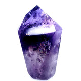 A natural purple amethyst crystal point tumbled into a polished geometric shape, shown against a solid white background.