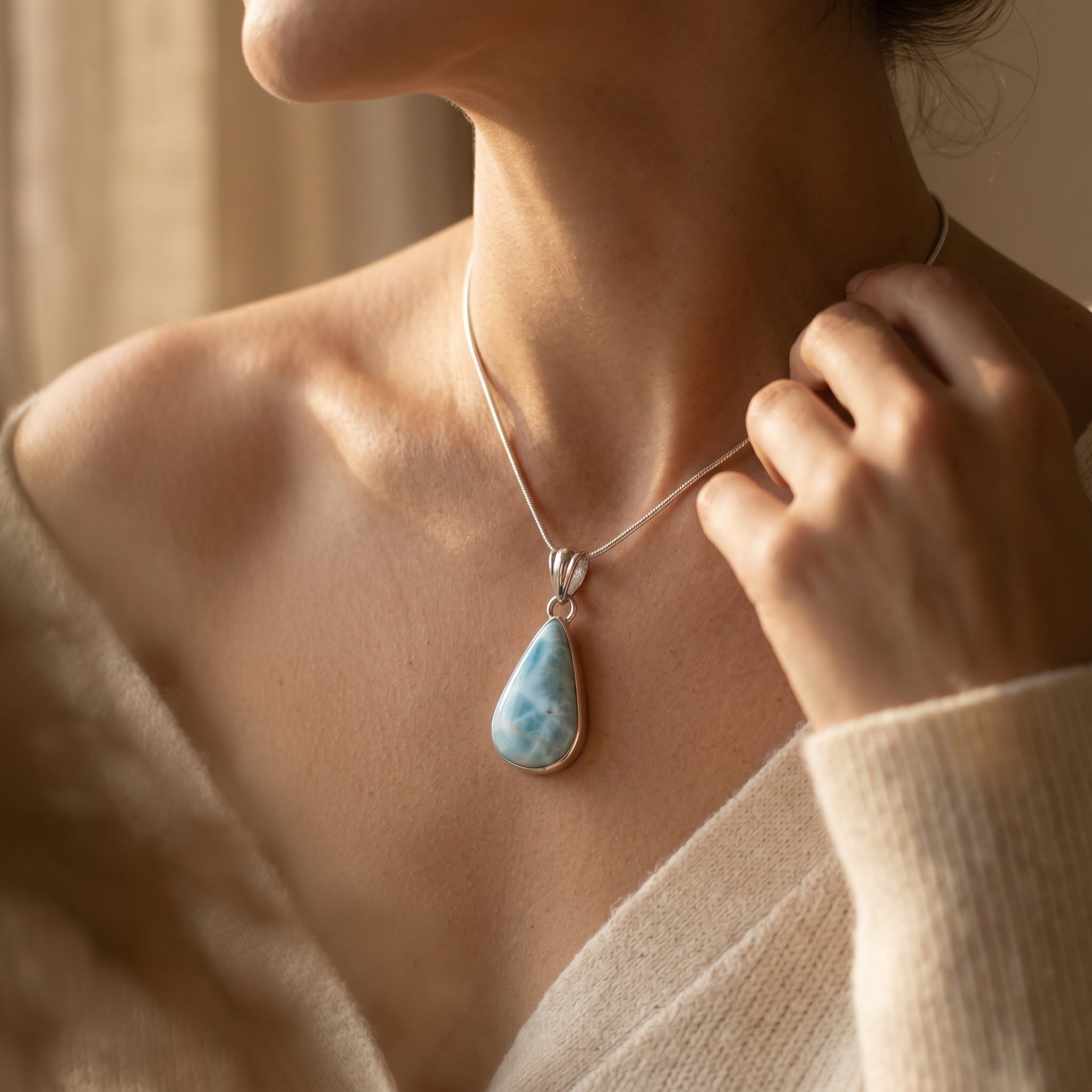 Larimar sterling silver pendant worn on model with pear shaped blue stone