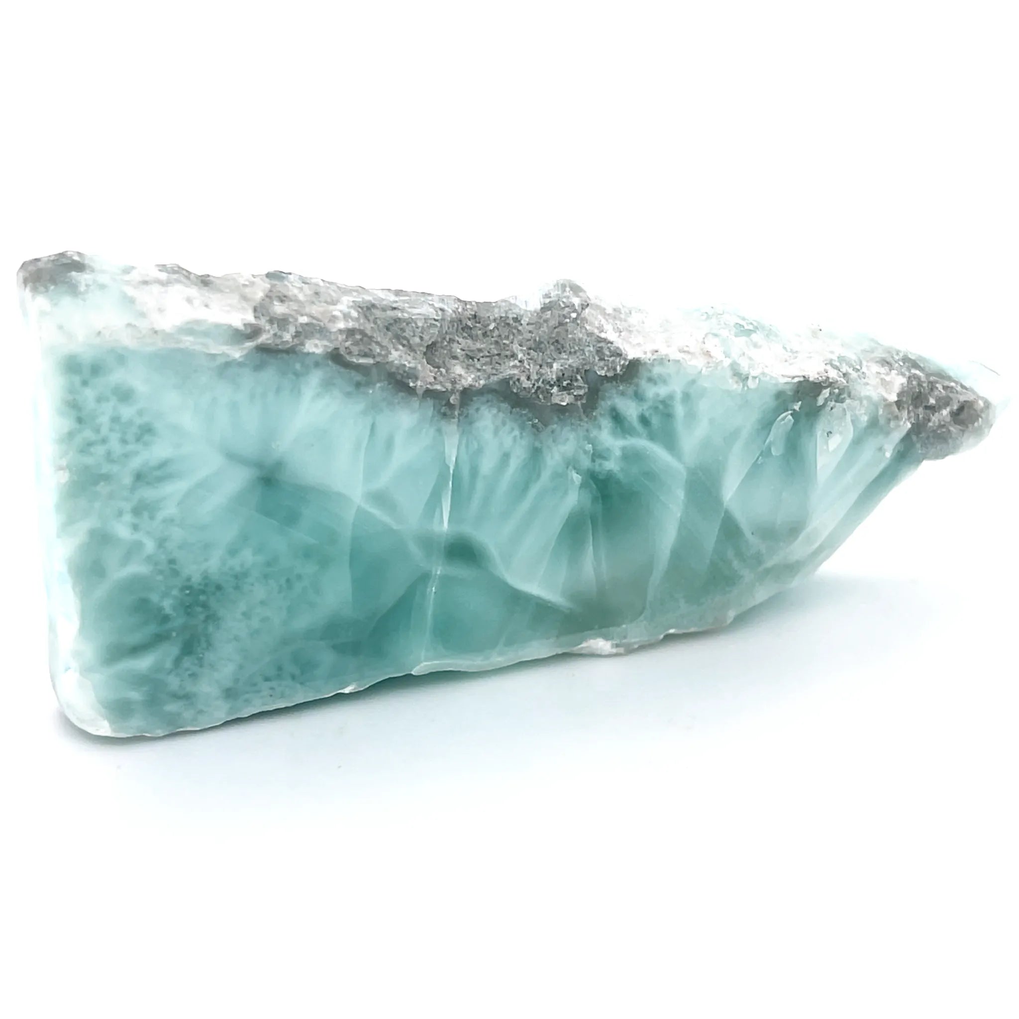 Side view of Larimar slice showing volcanic matrix and polished gemstone face