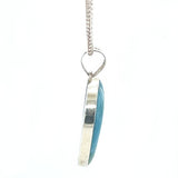 Side view of Larimar silver heart pendant showing polished gemstone setting