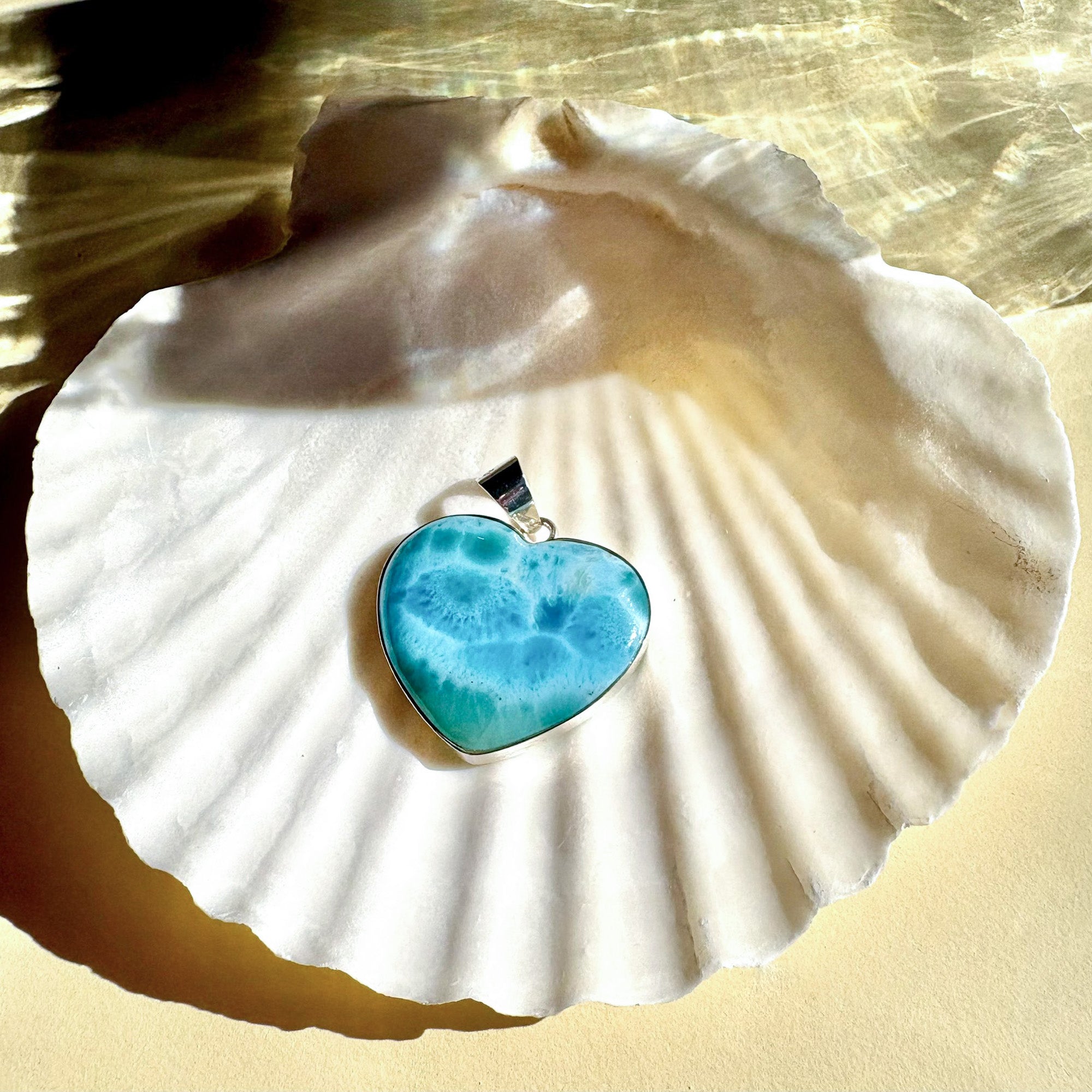 Larimar silver heart pendant styled on shell with Caribbean-blue stone
