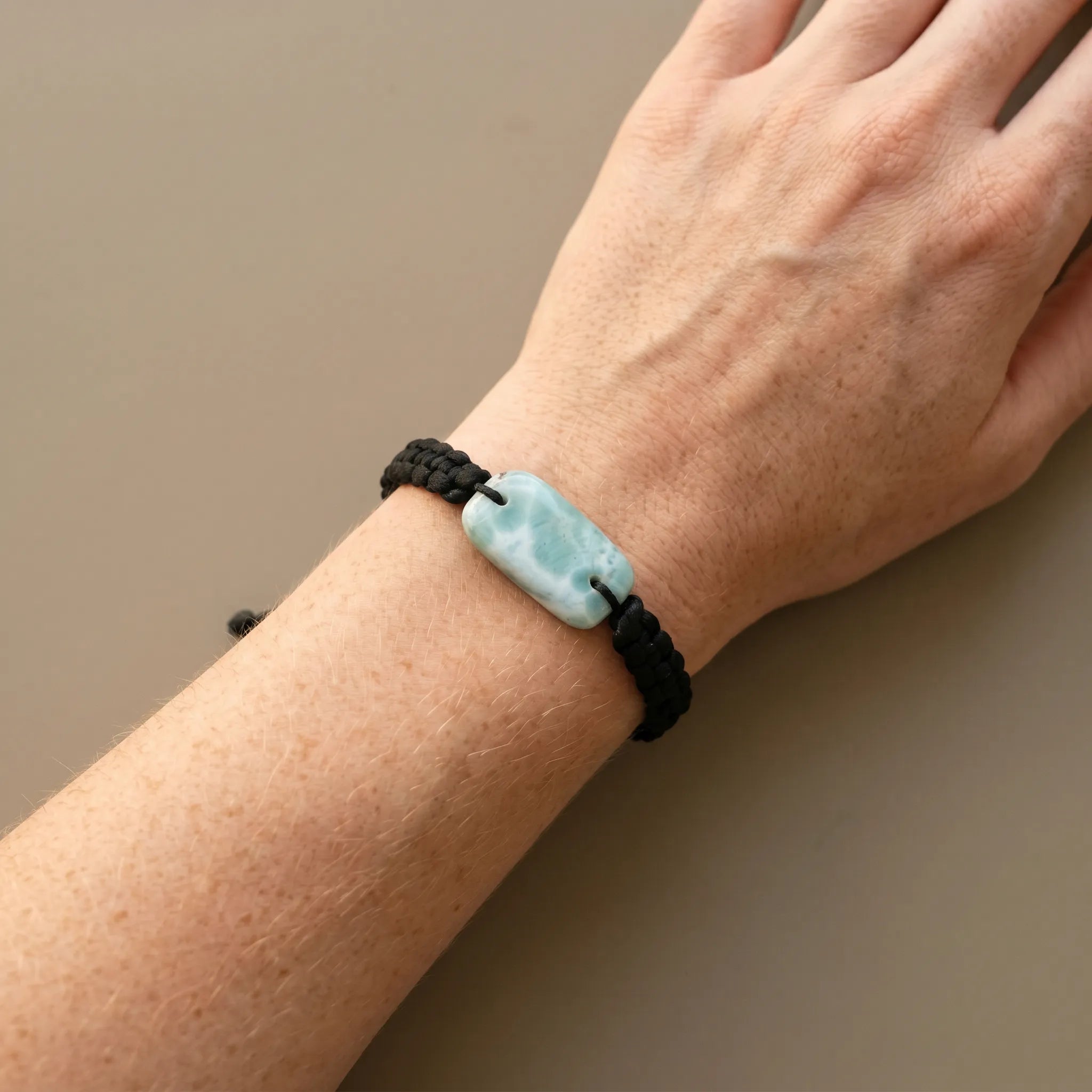 Larimar crystal bracelet worn on wrist with black adjustable cord